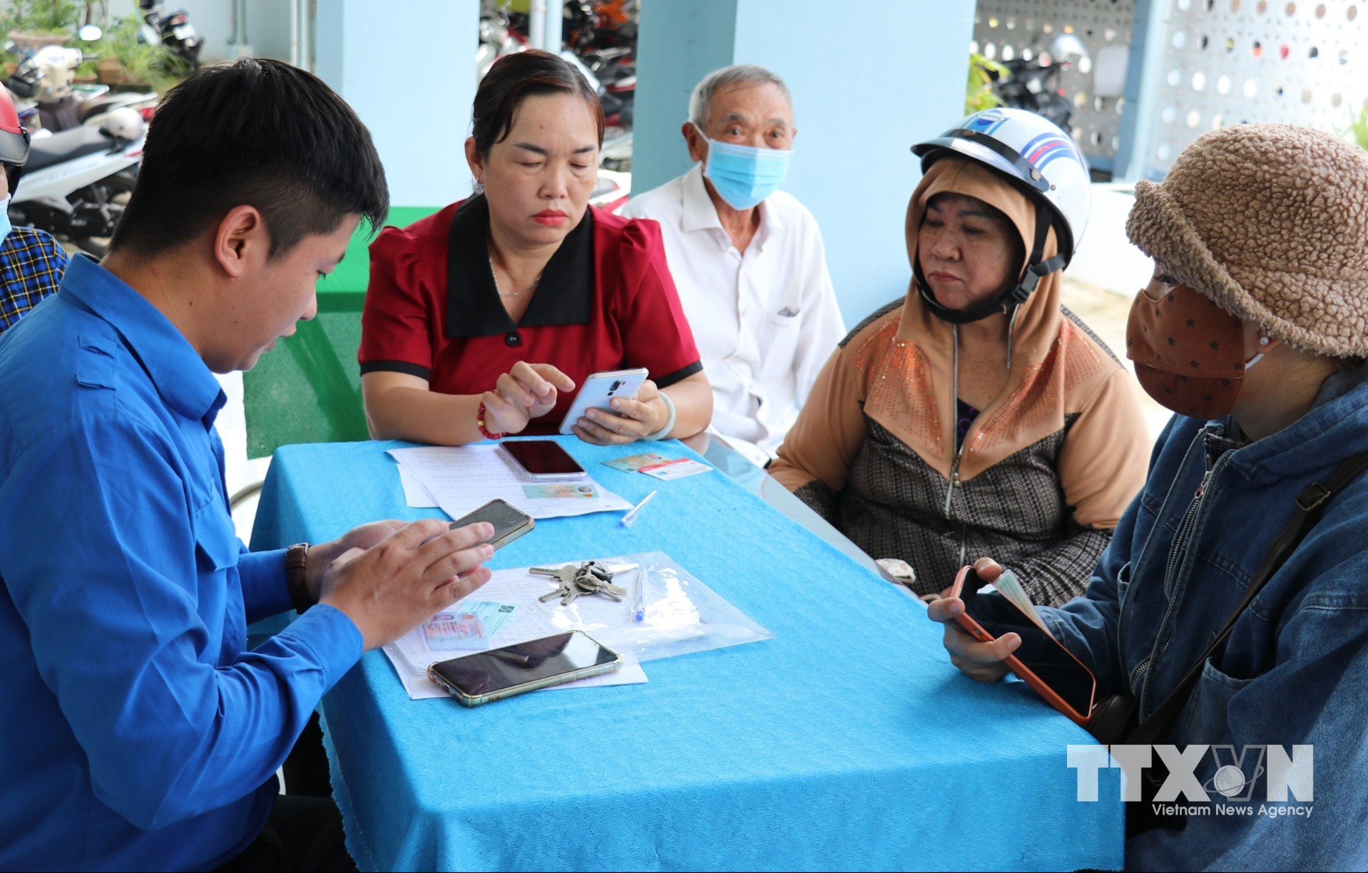 Bà Trương Thị Thanh Thúy (thứ hai, trái sang), Phó Chủ tịch UBND xã Bình Ninh, tỉnh Đồng Tháp, tham gia hỗ trợ người dân tích hợp thẻ bảo hiểm y tế trên VNeID. (Ảnh: Hữu Chí/TTXVN)